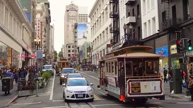 Rue du centre de San Francisco avec plusieurs voitures en circulation, illustrant la conduite et le trafic en ville.